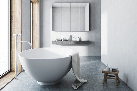 White bathroom, white tub, concrete floor