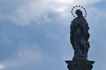 Obraz premium Statue of saint with cloudy background