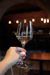 A glass of white wine in a woman's hand