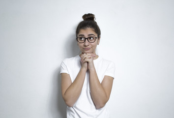 A pretty girl in glasses thinks about the idea. A young Indian woman reflects thoughtfully about something.