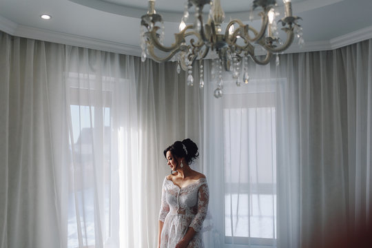 portrait of a beautiful cute bride in a boudoir in a bright morning room
