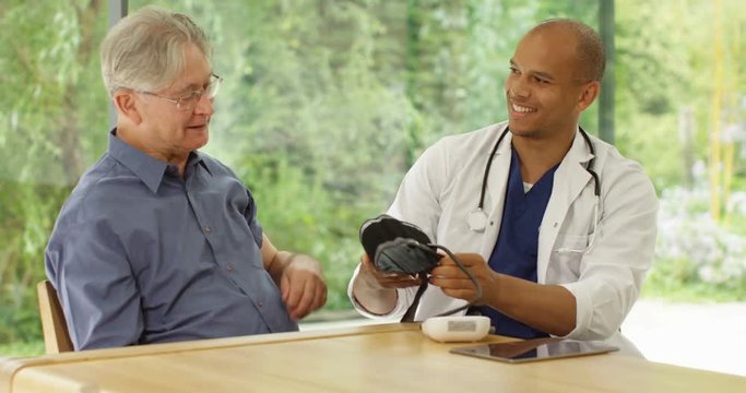 4K Happy senior man getting a check up with friendly doctor in his office