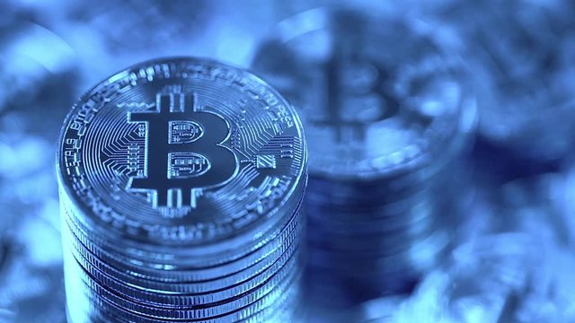 Bitcoins in blue light. Cryptocurrency Bitcoin, BTC, Bit coins, blockchain technology, bitcoin mining concept, macro shot of bitcoins with variable focus