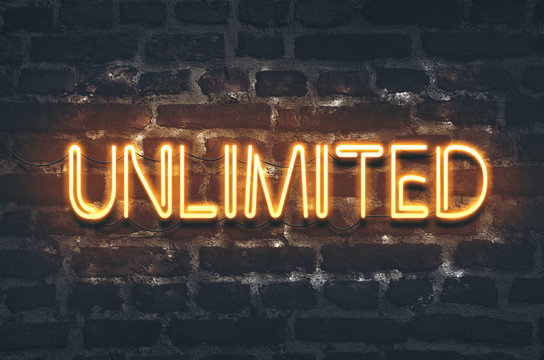 Unlimited neon sign on dark brick wall background