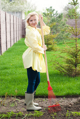 Gardener working with gardening tools in the garden - young woman at back yard