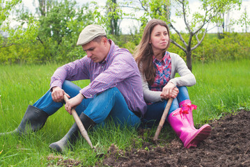 Gardeners working with gardening tools in the garden - family at back yard