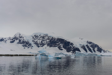 Antarctic landscape with icebergs and reflection