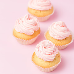 Cupcake decorated with pink buttercream on pastel pink background. Sweet beautiful cake. Square banner, greeting card for birthday, wedding, women's day. Close up photography. Selective focus
