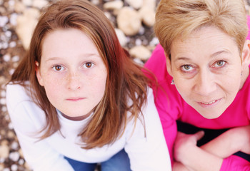 Happy mother and daughter standing in spring blossom park