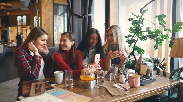 Four beautiful young woman doing selfie in a cafe, best friends girls together having fun