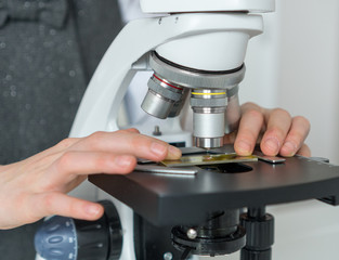 Little girl in science class using microscope. © M-Production