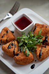 Camembert in batter, deep fried, with balsamic vinegar and arugula