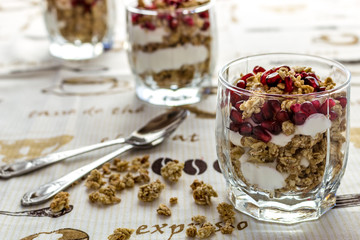 Three glasses with muslie and yogurt on white background