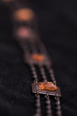 Part of a metal and amber necklace