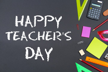 Fototapeta na wymiar Text chalk on a chalkboard: Happy Teacher's Day. School supplies, office, books, apple.