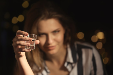 Young woman with glass of alcohol in bar