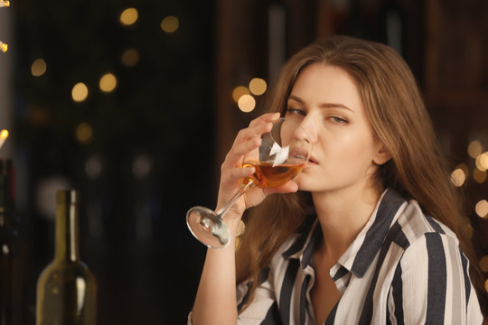 Young woman drinking wine in bar. Alcoholism problem