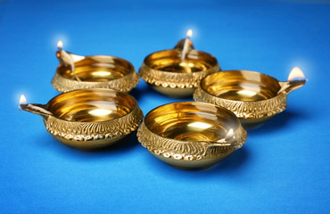 Diwali diyas or clay lamps on color background
