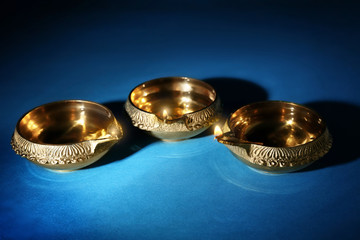 Diwali diyas or clay lamps on color background