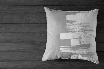 Stylish soft pillow on wooden background