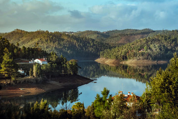 Fototapeta premium Trees and a house by the river