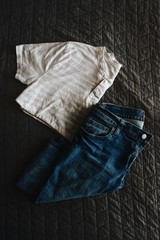 High angle view of folded jeans and t shirt on bed - 195550816