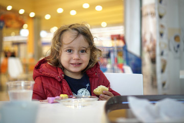 Obraz na płótnie Canvas happy little girl eating a cake