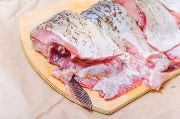 Raw fish  ide cut into pieces for cooking on a chopping Board