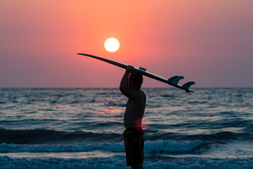 surfer walking on beach at sunset - 195552268