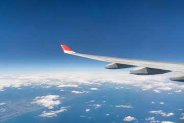 Fototapeta premium View from airplane window with blue sky and white clouds