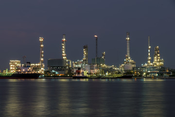 Landscape of oil refinery industry with oil storage tank in night.