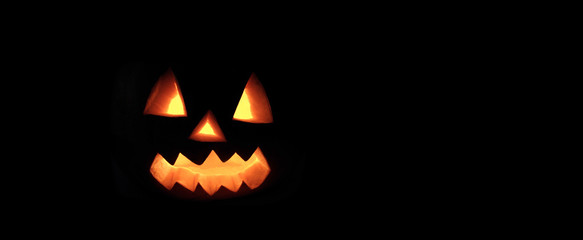 Halloween pumpkin with scary face on black background. © Hayati Kayhan