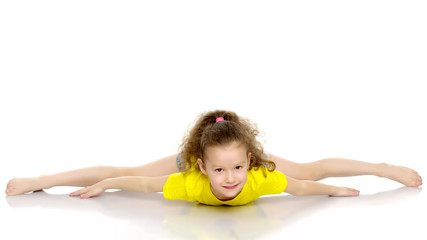 Obraz premium The little gymnast perform an acrobatic element on the floor.