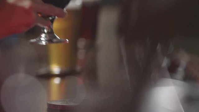 Beer being drank from snifter glass at a brewery.
