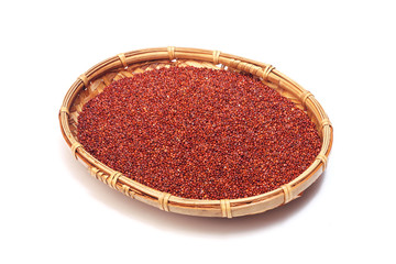Red quinoa grains in bamboo basket