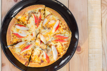 Pizza on wooden background top view.