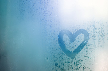 The heart is painted on the misted glass in the winter