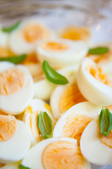 Boiled eggs sliced half and basil leaves