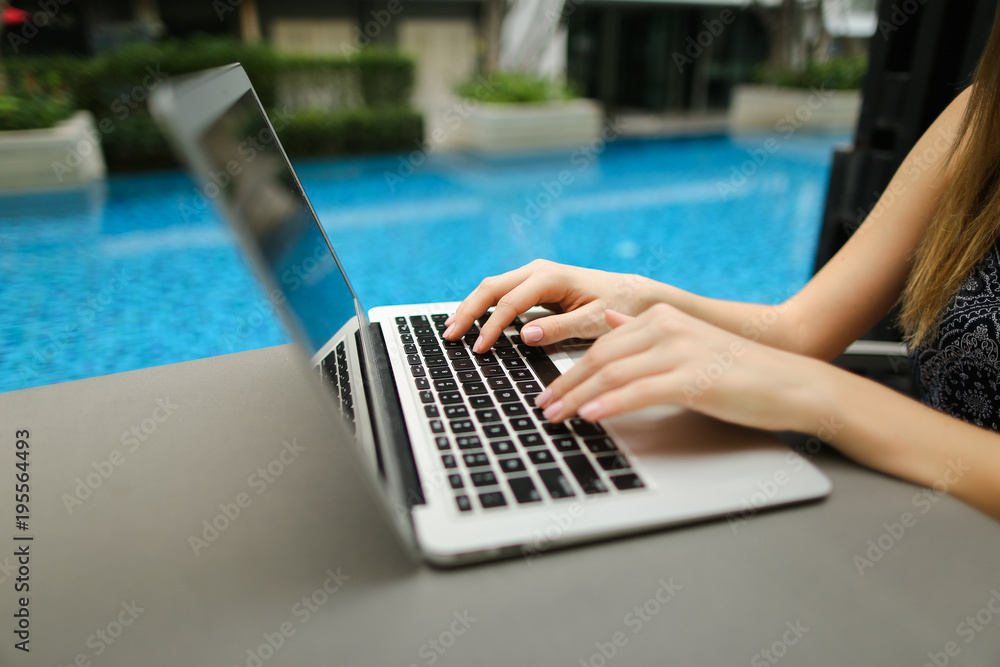 Wall mural fingers typing on the computer keyboard. close up portrait of woman hands pressing buttons on laptop