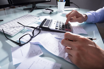 Close-up Of A Businessperson's Calculating Receipt