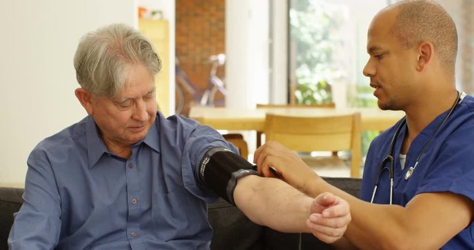 4k, Shot of an African American doctor checking a senior patient's blood pressure. Slow motion.