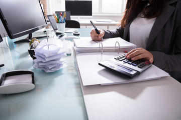 Businesswoman Calculating Invoice