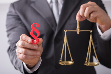 Judge Holding Paragraph Symbol And Justice Scale