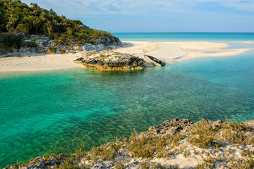Fototapeta na wymiar A small boat pulled up onto a perfect, isolated beach on Shroud Cay in the Exumas, Bahamas.