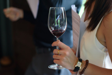 Woman holding a glass of wine at a party.