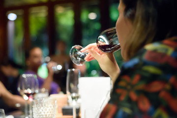 Woman holding a glass of wine at a party.