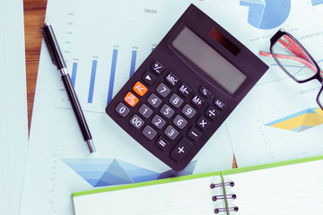 Top view of the businessman's work, calculator placed on the table.