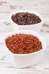 Red and black rice in glass bowls, healthy nutrition concept