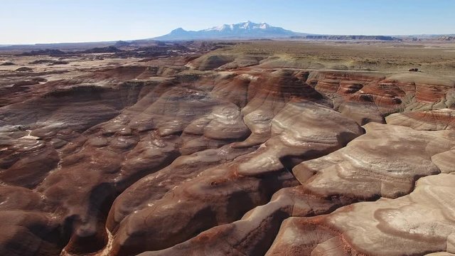 Panning aerial view over Mars like landscape in the Utah desert viewing the Henry Mountains.