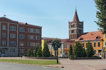Obraz premium View of the central square in Pravdinsk (prior Friedland) with the St. Great Martyr George the Victorious Church and other historic buildings. Kaliningrad Oblast, Russia. The city was founded in 1312.